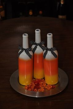 three orange and yellow bottles sitting on top of a plate with confetti in them