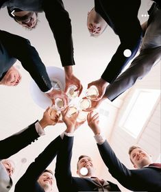 a group of people standing around each other holding hands in the middle of a circle