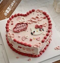 a heart shaped cake with hello kitty decorations