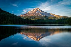 a mountain is reflected in the still water