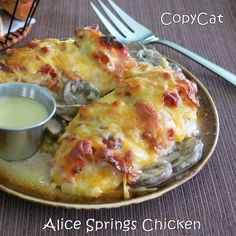 a plate topped with lasagna covered in cheese next to a bowl of sauce