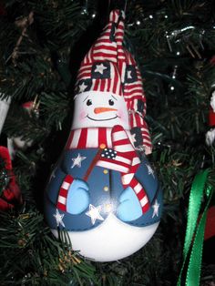 a snowman ornament hanging from a christmas tree