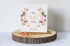 a happy birthday card sitting on top of a tree stump next to a pair of scissors