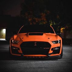 an orange sports car parked in the dark