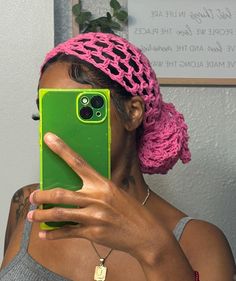 a woman taking a selfie with her cell phone in front of her face and wearing a pink headband