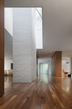 an empty living room with wood floors and white bricks on the wall in the center