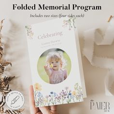 a person holding up a book with the title folded memorial program written in front of it