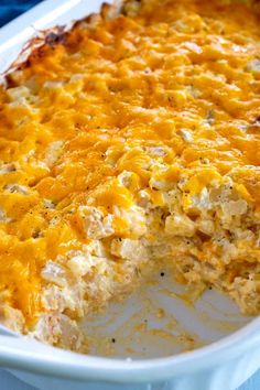 a casserole dish with cheese and chicken in it on a blue table cloth