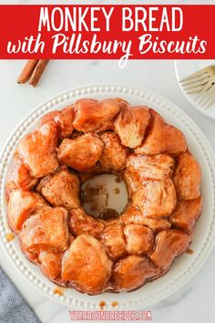 a monkey bread bundt on a white plate with cinnamon sticks around it and the words monkey bread with pillsbury biscuits