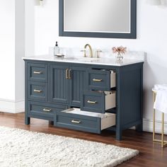 a bathroom vanity with two drawers and a large mirror above it, along with a rug on the floor