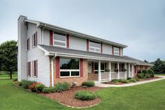 the front of a two story house with landscaping around it