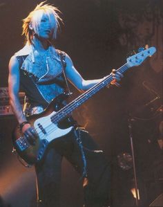 a woman with blonde hair playing a bass guitar