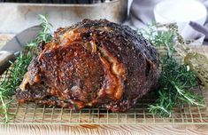 a large piece of meat sitting on top of a cooling rack next to a knife