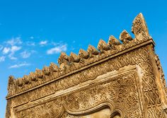 an intricately carved building with a blue sky in the background