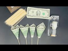 four green toothpicks, one dollar bill and some matches on a black table