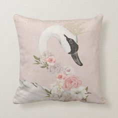 a white swan with pink roses on it's back is sitting on a pillow