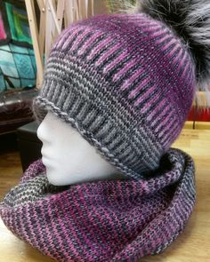 a mannequin head wearing a knitted hat with a pom - pom