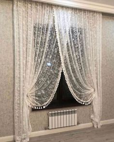 a window with sheer curtains and a radiator in front of it, next to a radiator