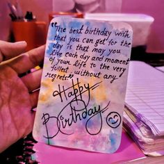 a hand holding a birthday card with writing on it