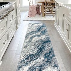 a blue and white area rug in a kitchen next to a table with chairs on it