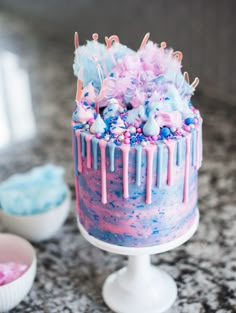 there is a cake with pink and blue icing on the top that has sprinkles all over it