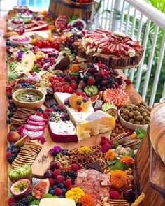 a table filled with lots of different types of food on top of wooden trays