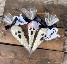 three halloween corn cobs wrapped in cellophane and tied with black ribbon on wooden planks