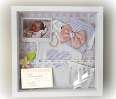 a baby's photo in a white frame with a pink bow and other items