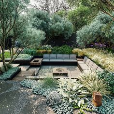 an outdoor seating area surrounded by plants and trees