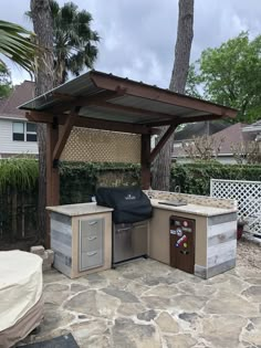 an outdoor bbq with grill, sink and cabinets