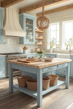 a kitchen with blue cabinets and wooden flooring is pictured in this image, there are baskets on the island