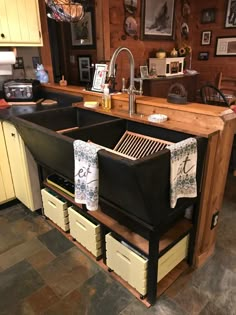 a kitchen with an island that has two sinks and drawers under the faucet