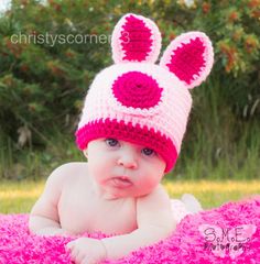 a baby wearing a pink and white crocheted hat with ears on it's head