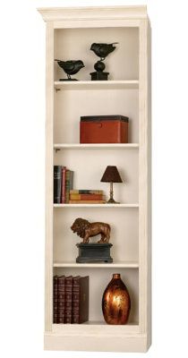 a white book shelf filled with lots of books and vases on top of it