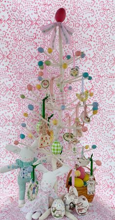 a pink and white wallpaper with a tree made out of toys on top of it