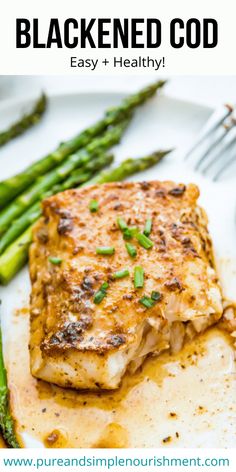 a white plate topped with fish and asparagus next to a fork on a table