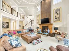 a living room filled with furniture and a flat screen tv mounted on the wall above a fireplace