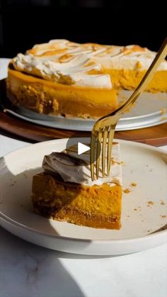 a piece of pumpkin pie on a white plate with a fork in it and another slice missing