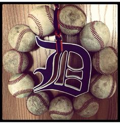 a wreath made out of baseballs with the word detroit tigers hanging from it's center