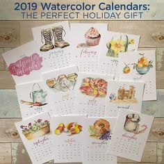 several calendars with pictures of different things in them on a wooden table next to a cupcake