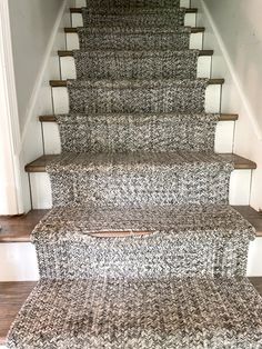 a carpeted stair runner on the bottom of a set of stairs