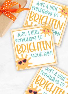 three greeting cards with the words brighten your day on them and a present wrapped in brown paper