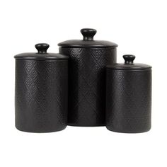 three black canisters with lids on white background