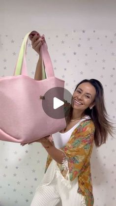 a woman holding a pink bag in front of her face