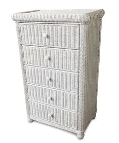 a white wicker chest with four drawers and one drawer on the bottom, in front of