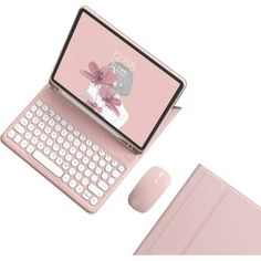 an open laptop computer sitting on top of a pink surface next to a keyboard and mouse