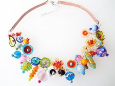 This Statement Charm necklace is sure to just make you feel happy. this Colorful Rainbow Bib necklace is bright, abstract, and cheerful. Give this Funky necklace as a gift to the chic, fashion-forward woman in your life. These Glass Lampwork beads are handmade. With the multiple colors of blue, orange, green, pink, yellow, red, and black. you can wear this Funky jewelry with any outfit or dress. There are disk beads, round swirly beads, and many other adorable handcrafted glass beads which are m Kitsch Fashion, Lampwork Bead Necklace, Funky Necklace, Birthday Hats, Bubble House, Lampwork Necklace, Flower Statement Necklace, Geek Jewelry, Lampwork Jewelry