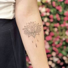 a woman's arm with a tattoo that has a lotus flower on the side