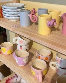 the shelves are filled with colorful cups and saucers