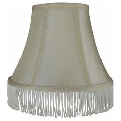 a white lamp shade with fringes on the bottom and side of the lampshade